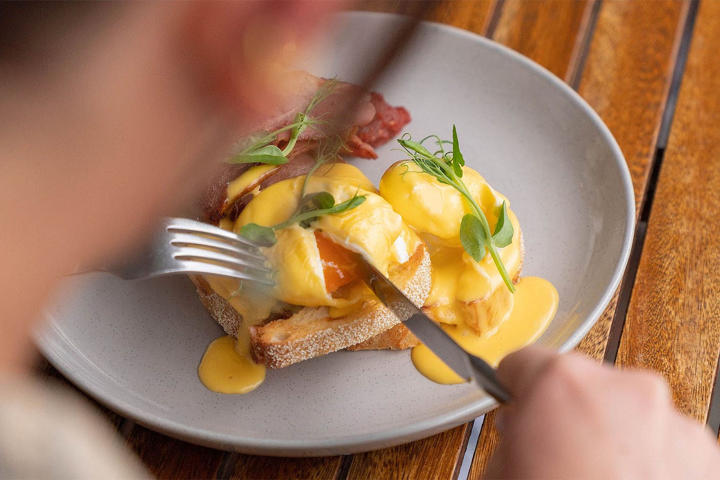 Someone tucks into a delicious eggs benny at The General.